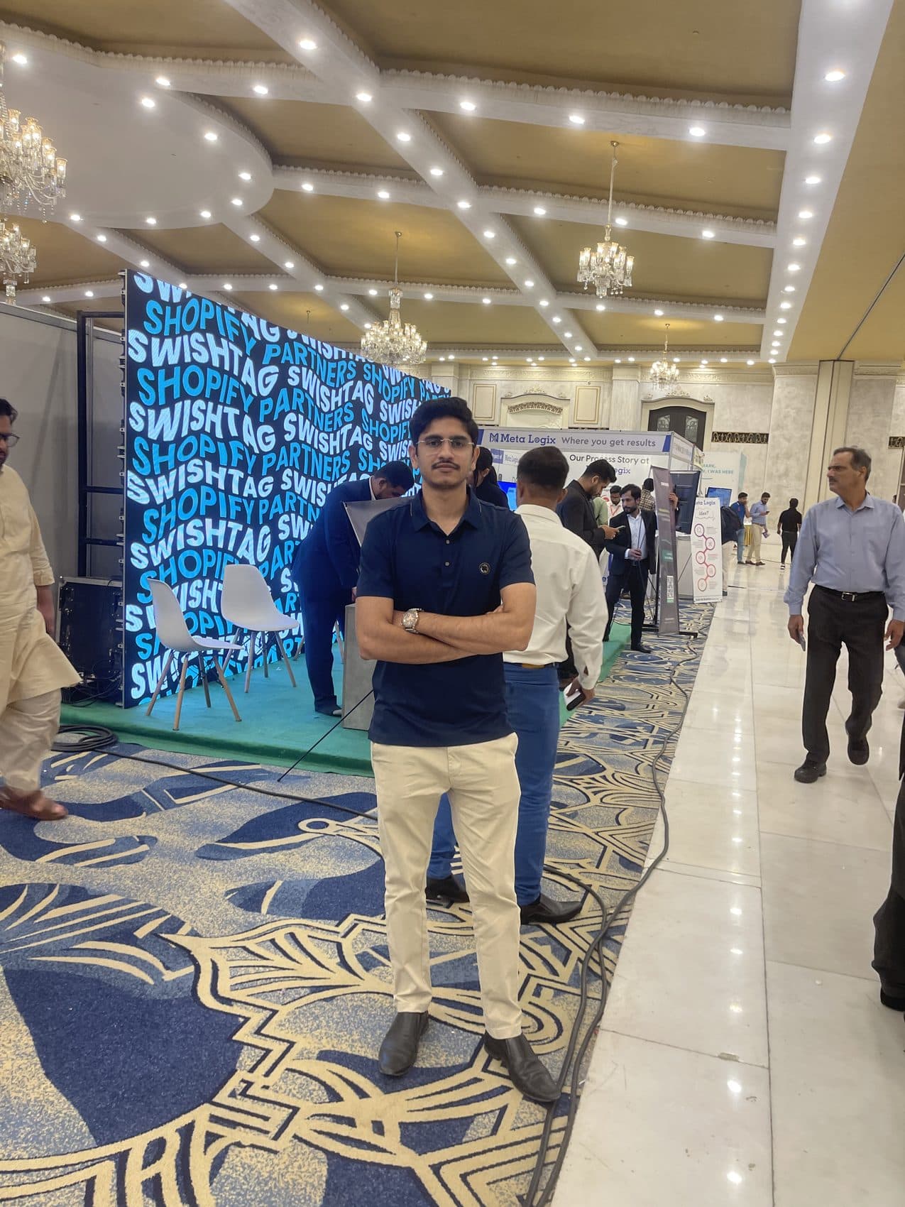 At an expo booth in a chandelier hall — networking proof