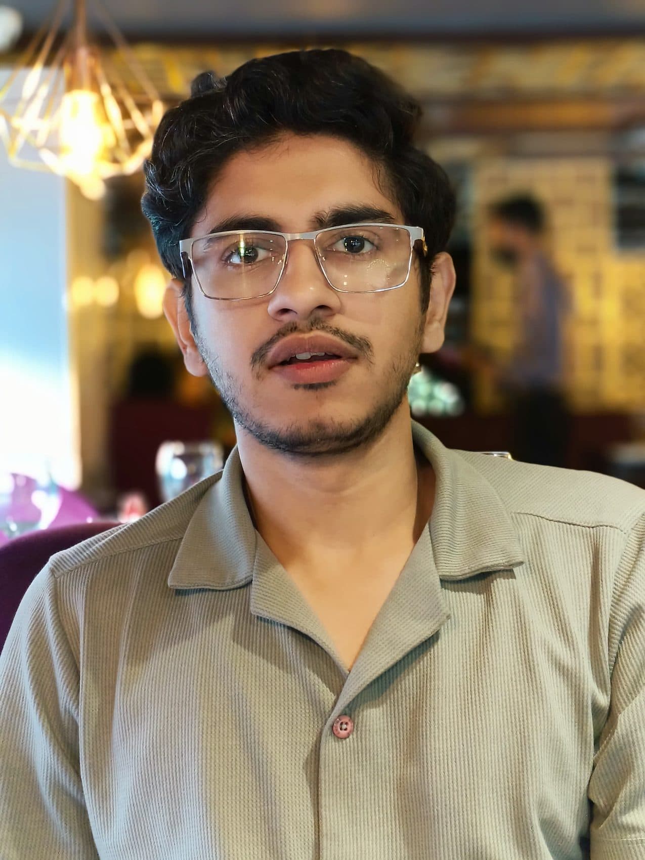 Close-up portrait in glasses and a beige shirt at a restaurant