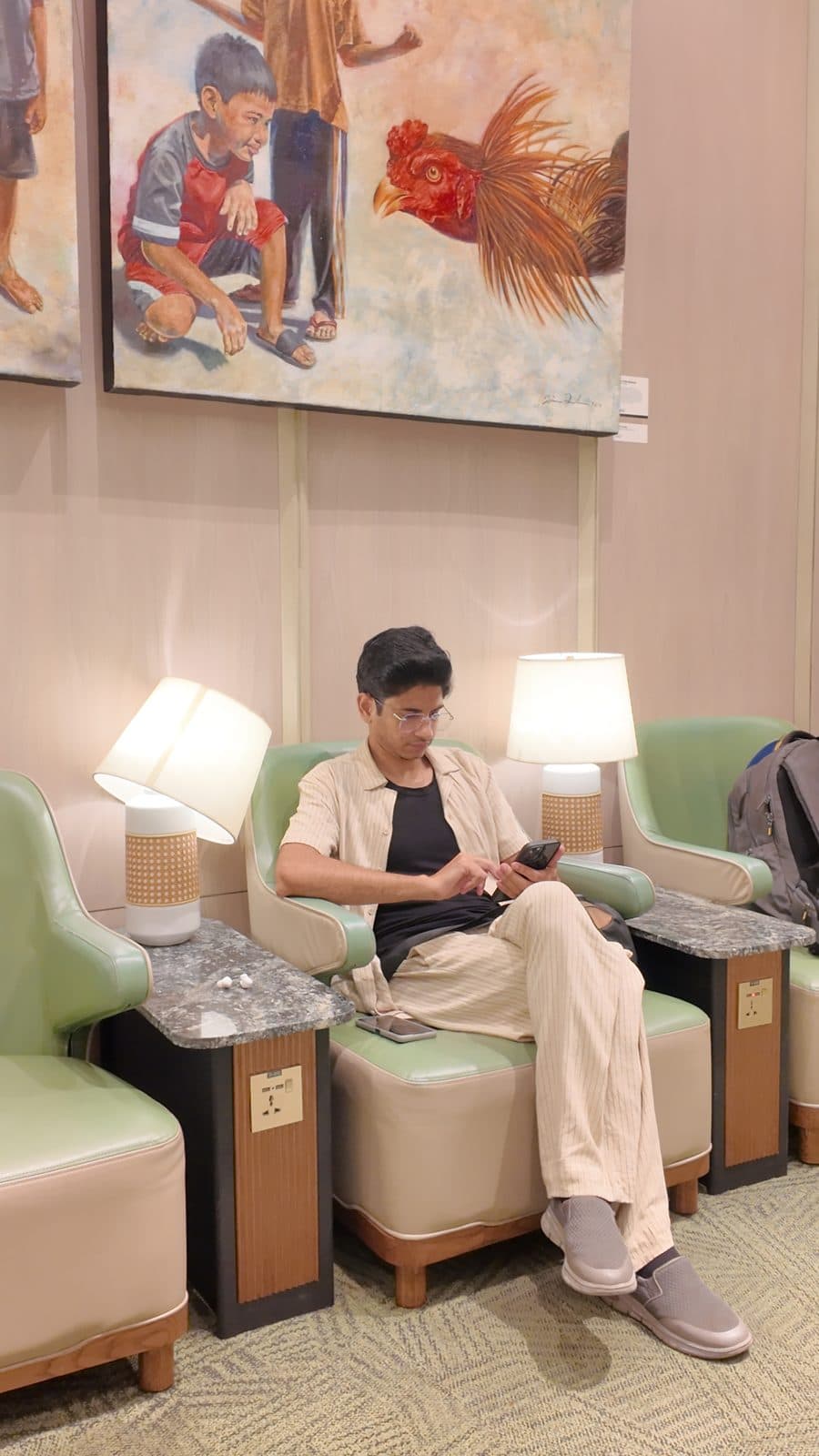 Airport lounge armchair between flights, phone in hand