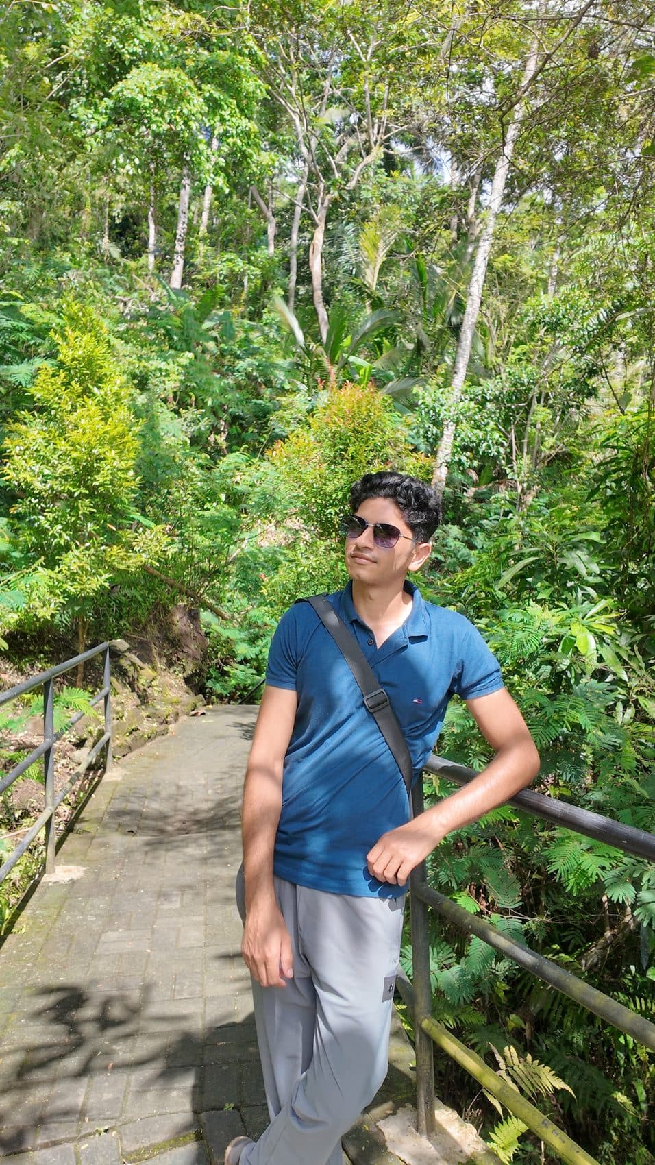 Leaning on a jungle rail in sunglasses, candid